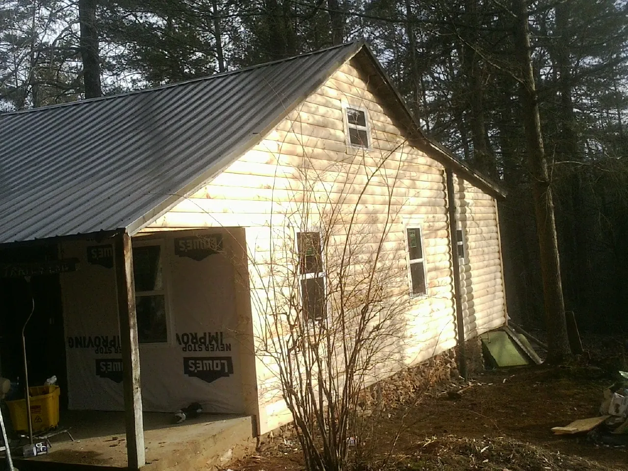 Log siding gable end under a dark metal roof edge in Pompton Plains