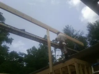 Carpenter setting a ridge beam over a new addition frame — Ice Dam Removal by Roofing Brothers in Pompton Plains