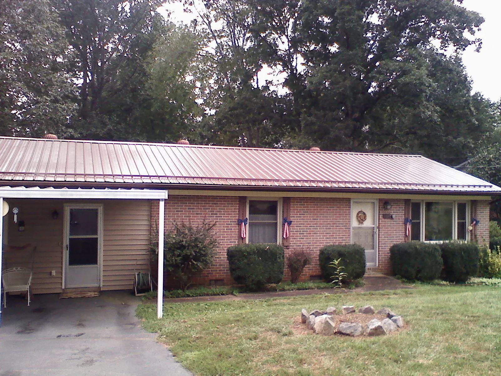 Bronze metal roof and carport on a brick ranch home — Roof Repair work by our crew in Pompton Plains